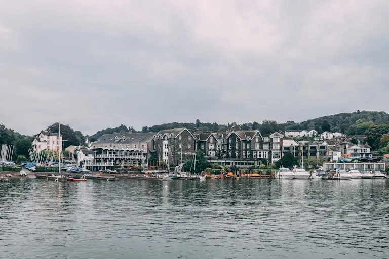 Hotels and guest houses lining the lake shore at Bowness-on-Windermere, with moored boats in the foreground